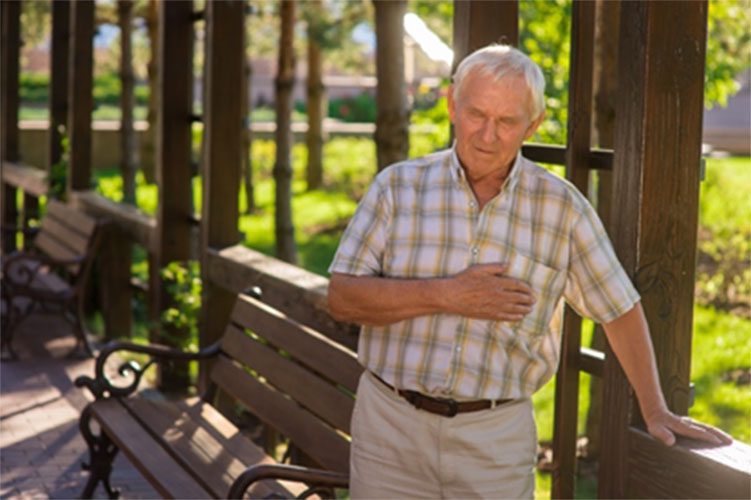 A man standing on the bench holding his chest.