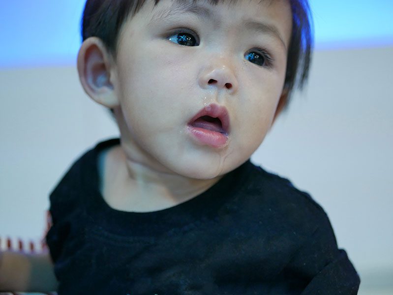 A young child with short hair looking up at the camera.