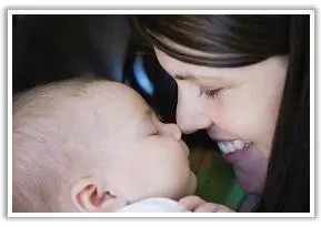 A woman holding a baby and kissing it